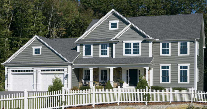 Roofing and siding on a new house with white picket fence